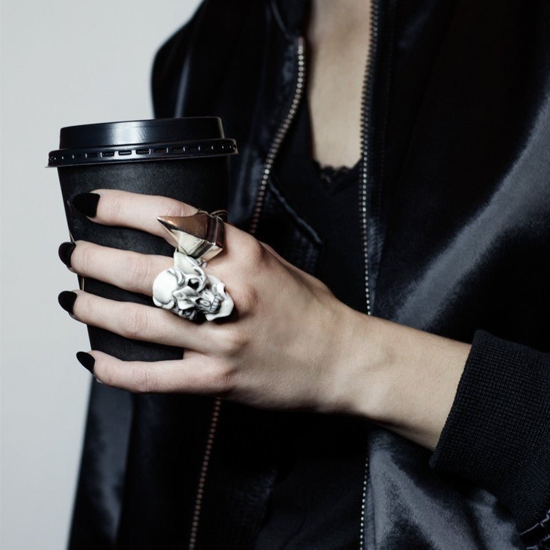 Orchid Skull ring on a female model's hand holding a cup of coffee with other ring