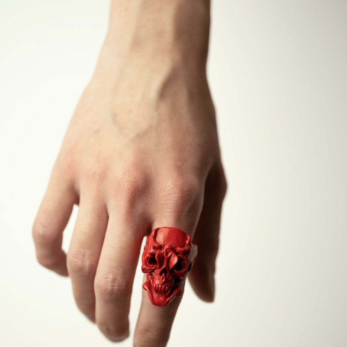 Orchid Skull ring, red variant, on a model's hand, on the index finger  