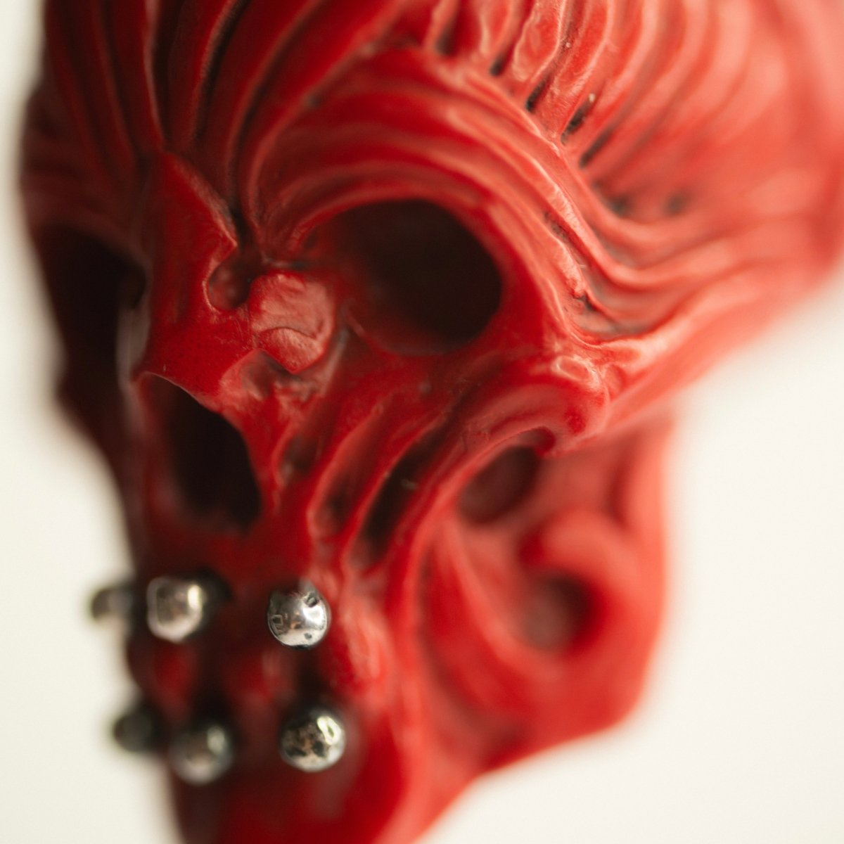 Ornate Skull pendant close up of a face of the skull, with focus on rich relief of the pendant