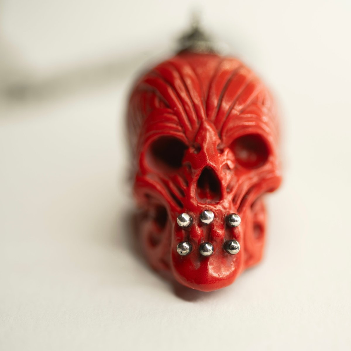 Ornate Skull pendant close up on sterling silver decoration of the skull, red variant