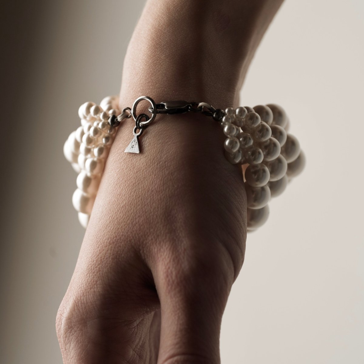 Multi-strand Pearl bracelet by Macabre Gadgets on a model's hand, close up of the clasp detail