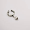 Pearl ear cuff by Macabre Gadgets on neutral surface showing sterling silver and glass pearl detail, no piercing required jewelry