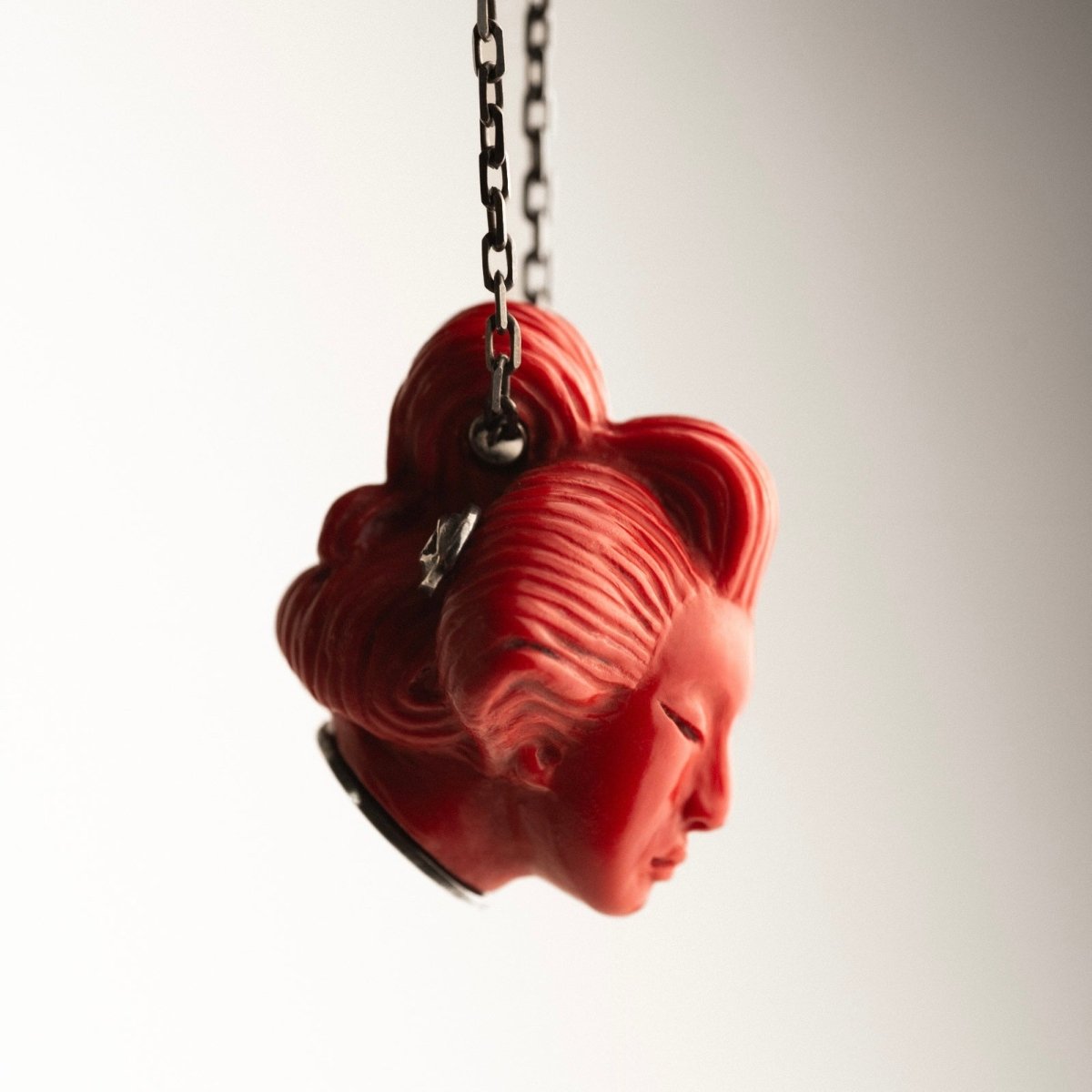 She pendant, red variant, different side view, sterling silver decoration and chain fixture are visible