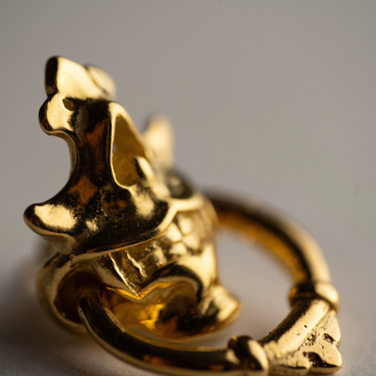 Silver Mask earring — gold plated variant — close up on ornamental relief and Hannya-inspired ornamentation