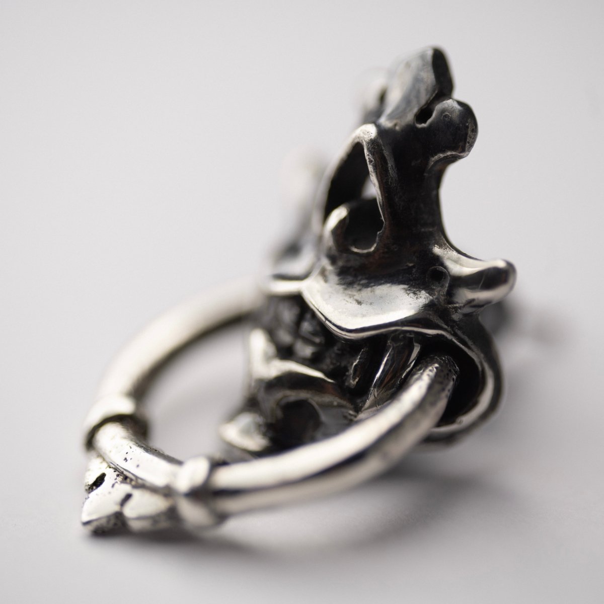 Silver Mask earring — side view showing depth and three-dimensional sculptural relief