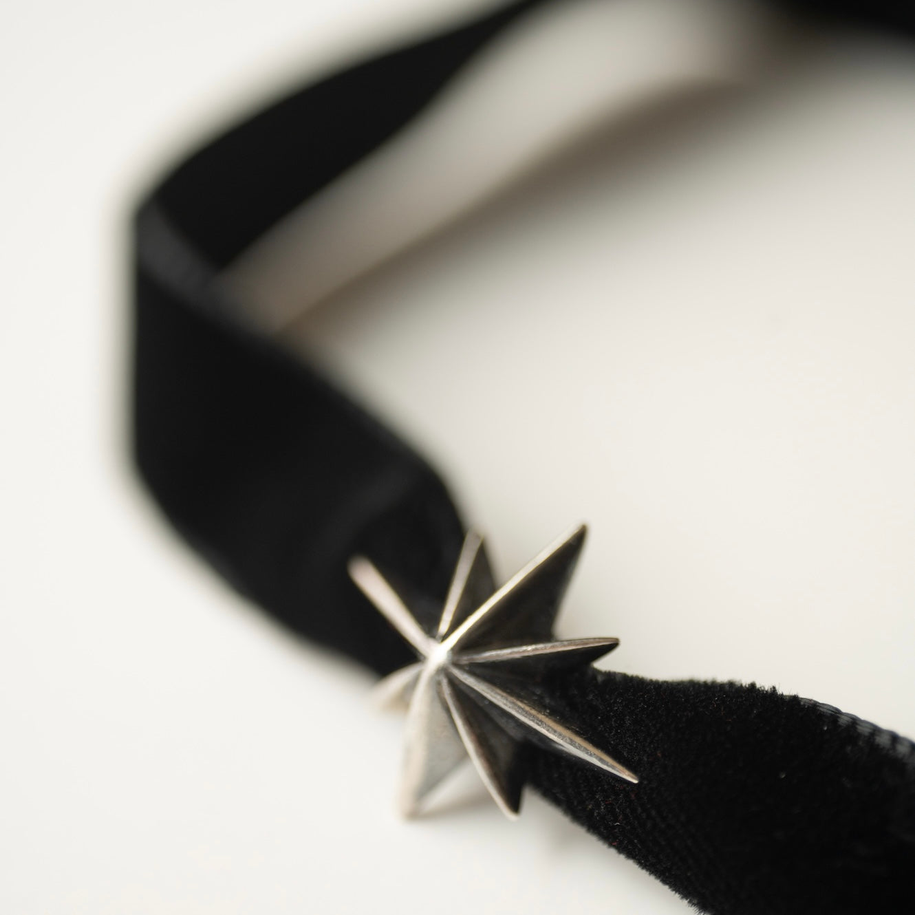 Silver Star Choker — close-up of mirror-polished 8-point geometric star, white background