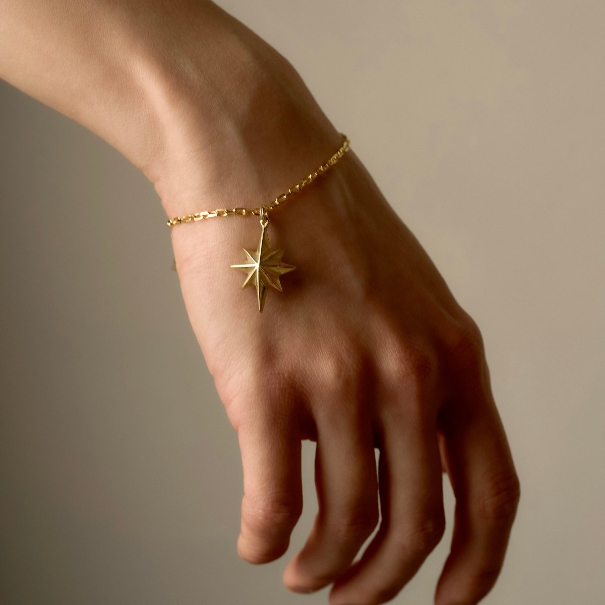 Star bracelet - gold variant - on female model's wrist, different angle