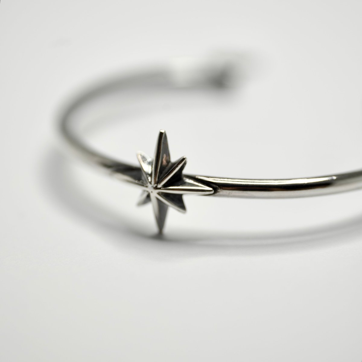 Star cuff bracelet on a white surface, close up on a star detail