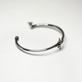 Star cuff bracelet placed on a white surface, focus on the star and gleaming sterling silver bangle