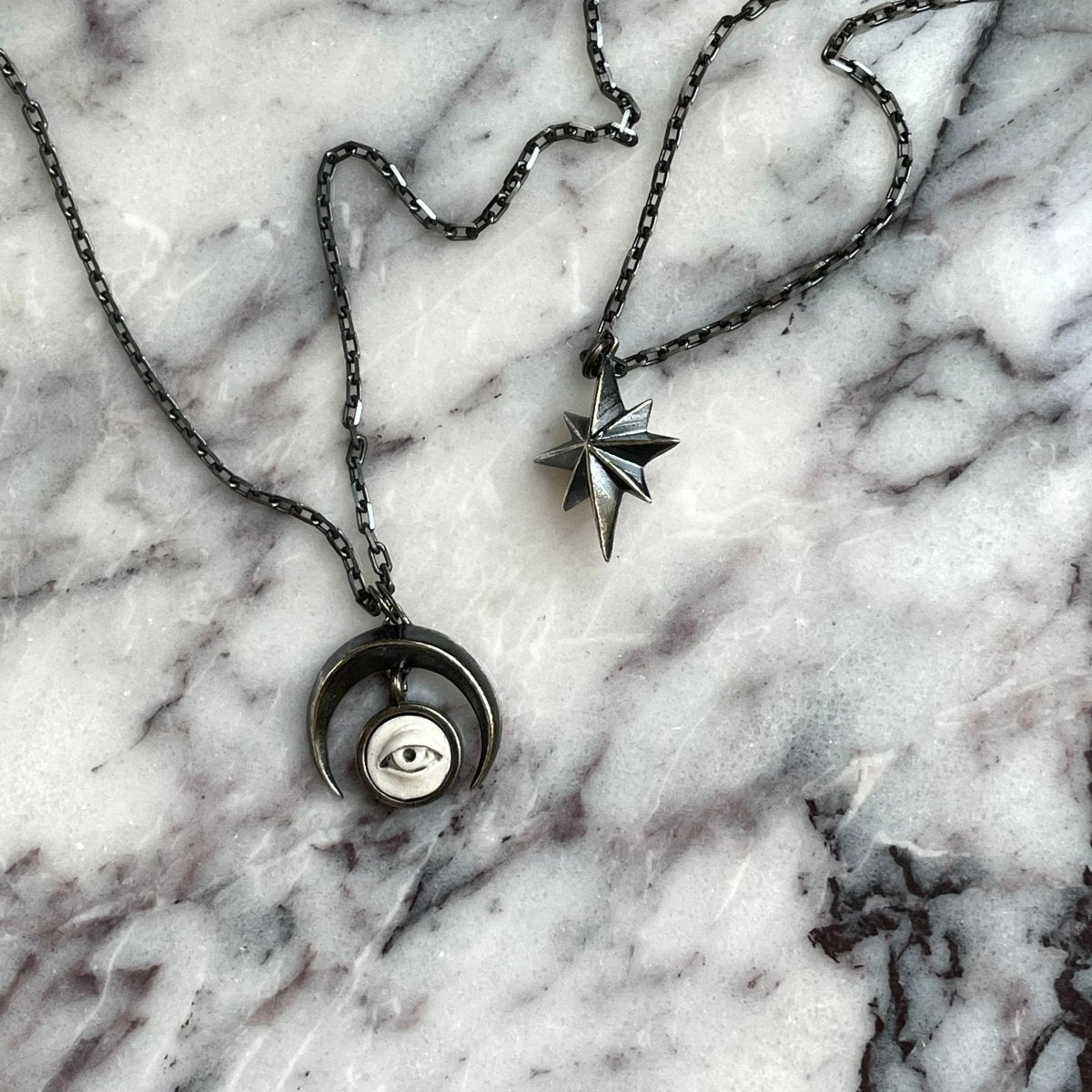 Star pendant with Crescent Oracle pendant on marble surface — celestial jewelry by Macabre Gadgets