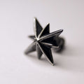 Star stud earring by Macabre Gadgets - silver variant - on a neutral surface, close-up of star-shaped earring