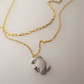 Achilles pendant from Macabre Gadgets’ THEA line. The pendant is crafted from bonded marble, portraying a serene male face, and is mounted on a gold-plated sterling silver chain.