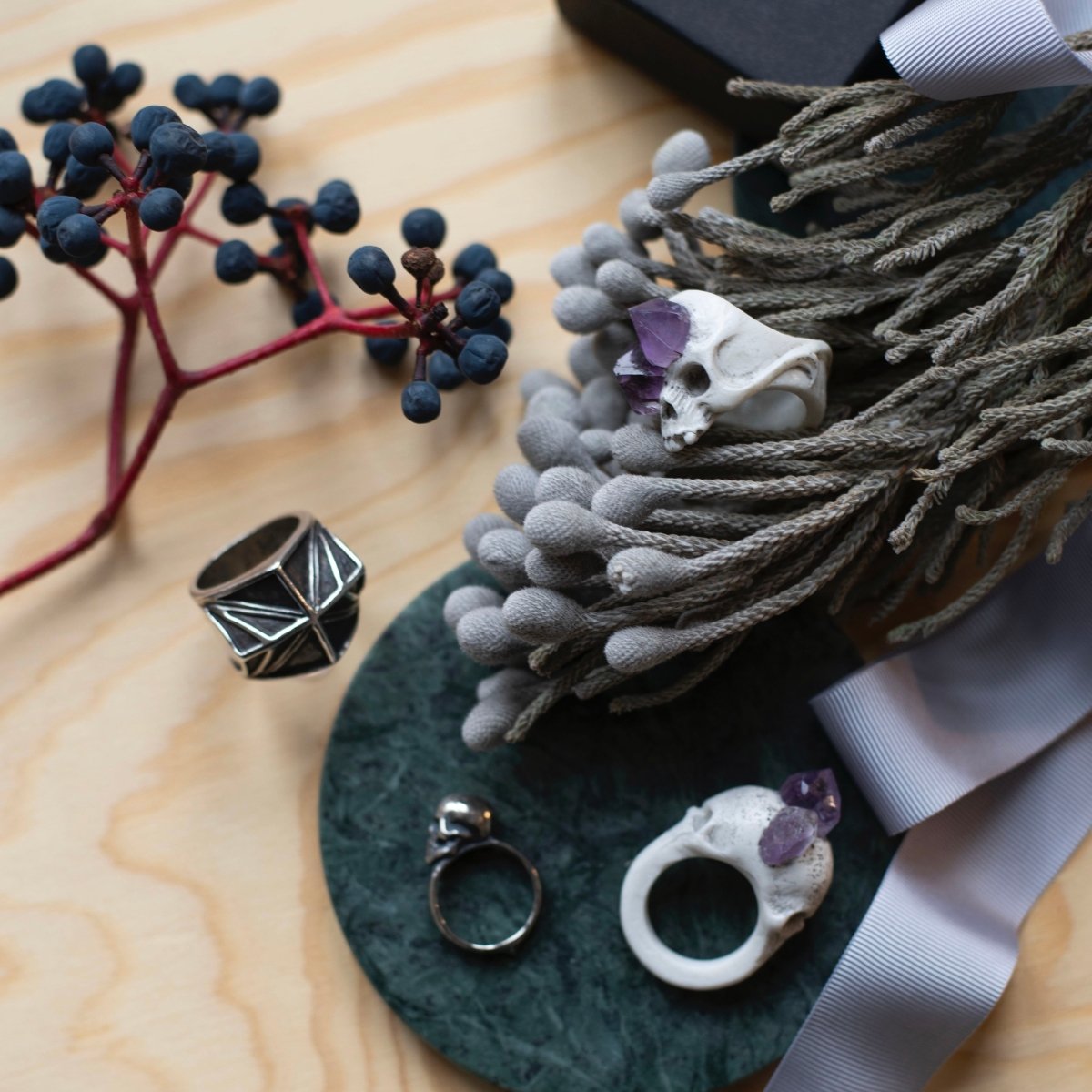 Amethyst Crystal Skull Ring - lifestyle picture with flowers, different textures  and other Macabre Gadgets rings