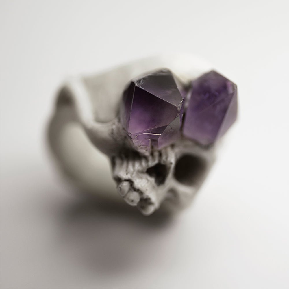 Amethyst Crystal Skull Ring close up with focus on one of the crystals, with every natural imperfection visible, skull is blurry