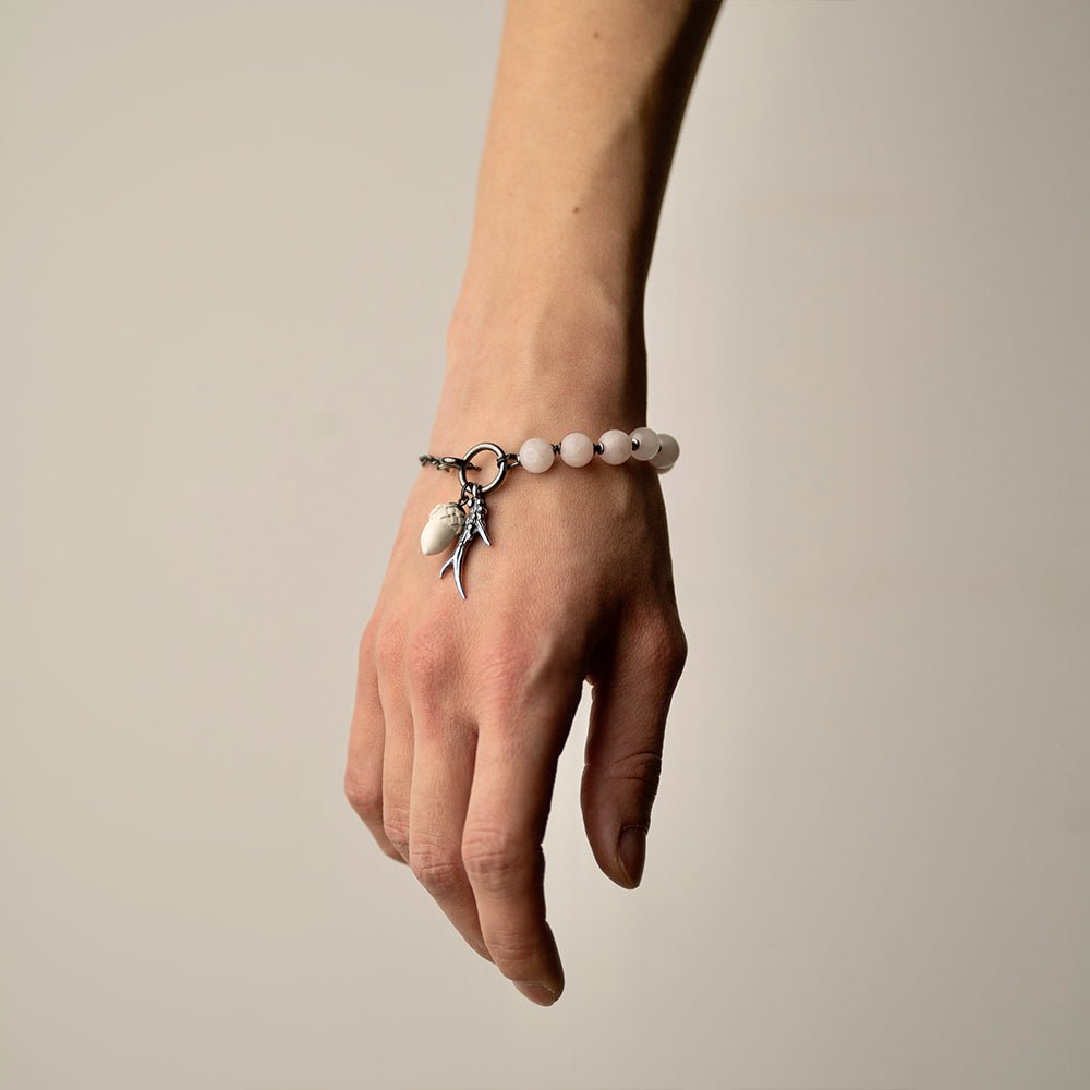 Silver Horn bracelet on a female model's hand, rose quartz part and charms are visible