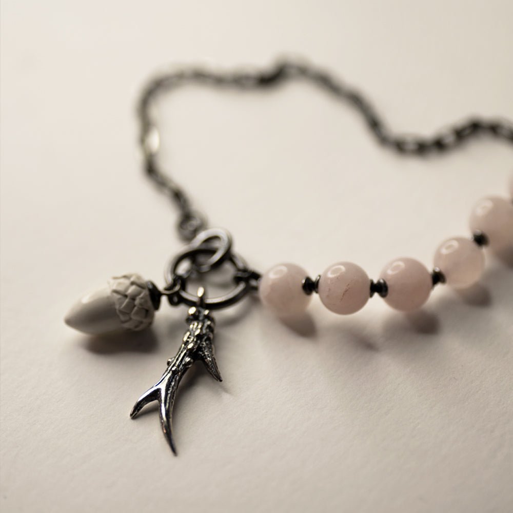 Silver Horn Bracelet placed on a white surface, silver horn and acorn charms are visible