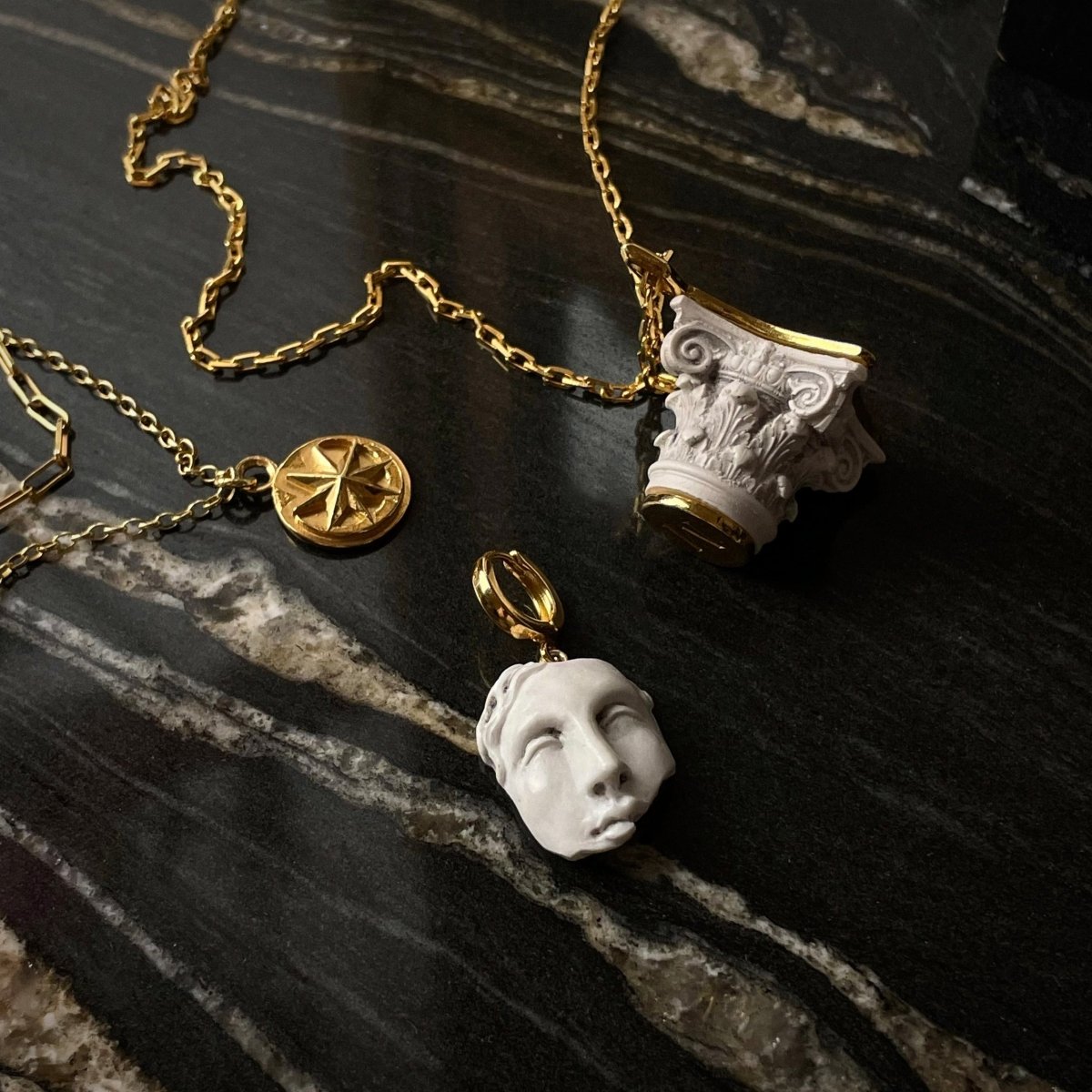 Aster pendant, Aster bracelet, Capital pendant and other jewelry by Macabre Gadgets on a black glossy marble surface
