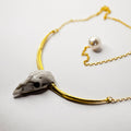 Ox Skull necklace hand crafted in gold and white marble on a minimalistic white surface