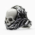 Sterling silver chunky ring with floral elements and skull centerpiece on white background