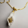 Capere Sidus pendant on an eggshell background, focus on gold plated silver star
