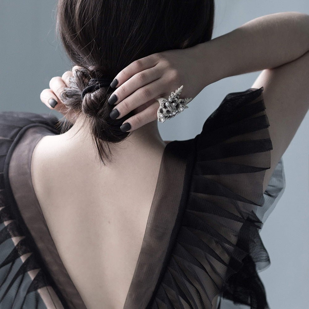 Female model in black evening dress wearing Coral Crown Skull ring — marble skull ring with pearl crown | Macabre Gadgets