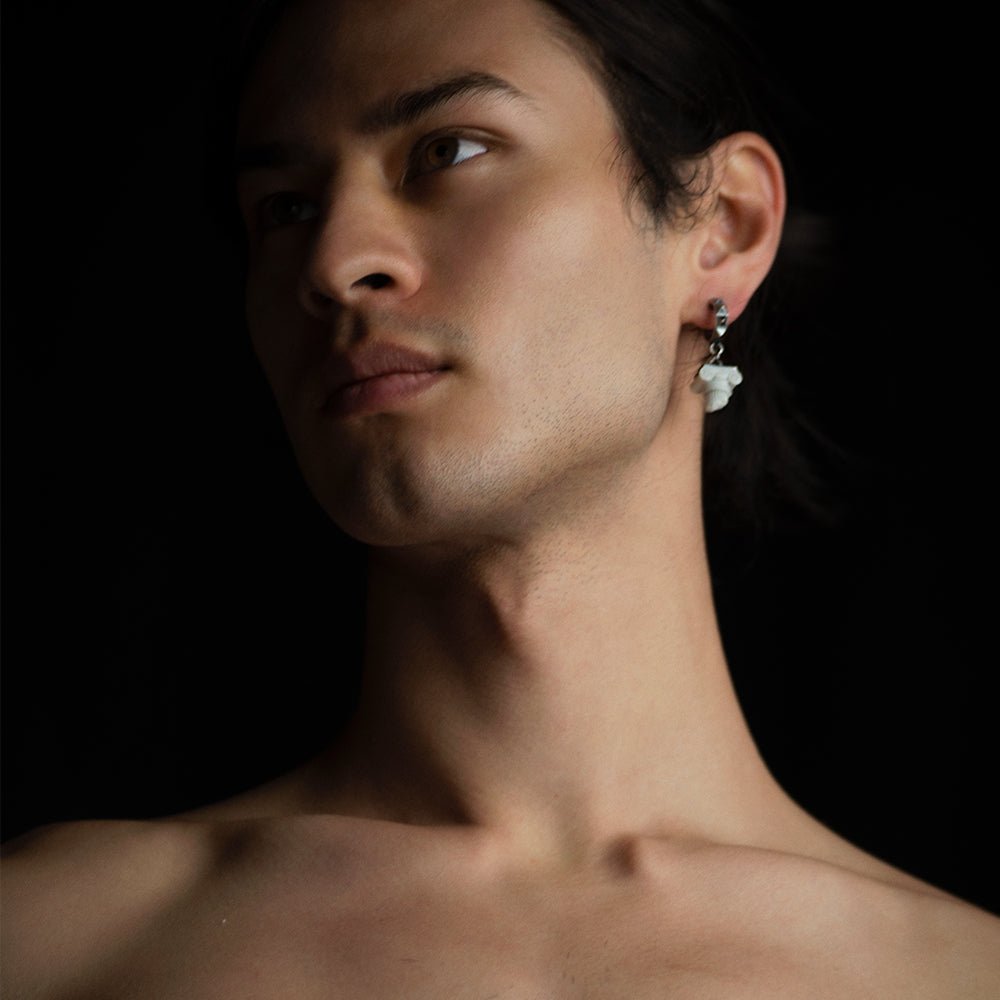 Ionic earring on a male model on dark background, architecture inspired jewelry in fashion editorial