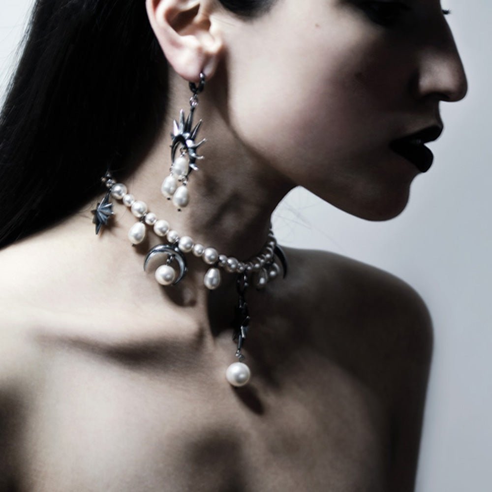 Stars and Moons choker by Macabre Gadgets and large pearl earring on a female model, with long black hair