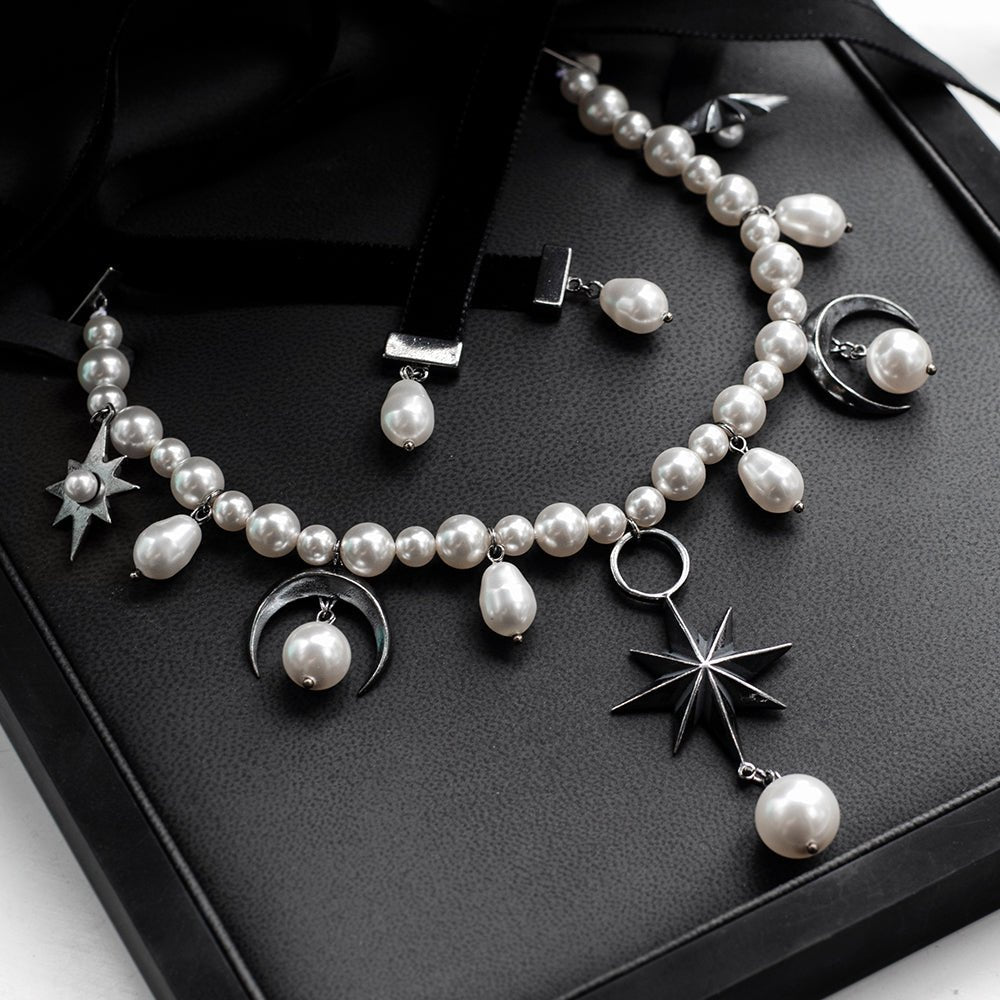 Stars and Moons choker placed in a jewelry box with faux leather interior, sterling silver moons and stars gleaming on a satin black surface