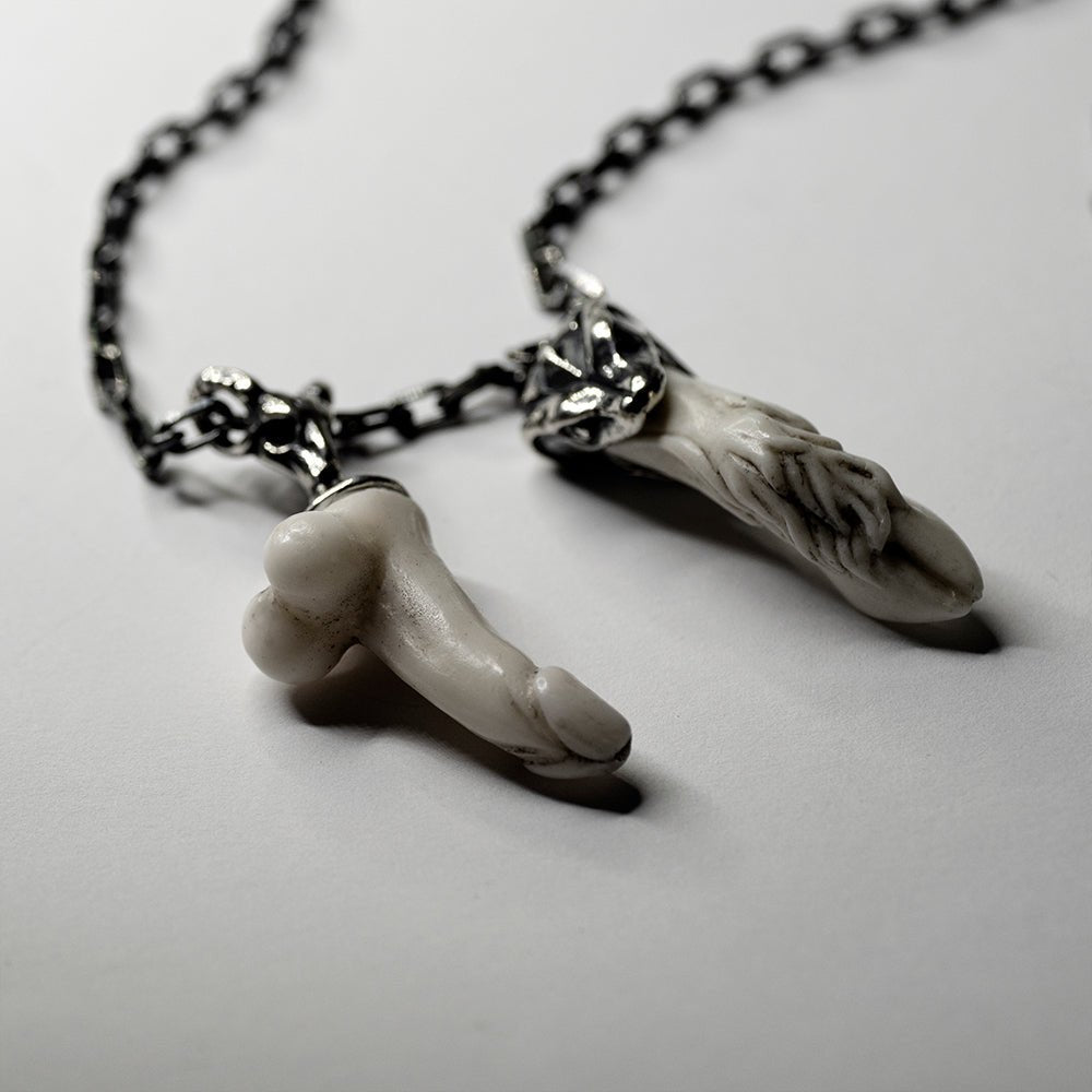 Faun Bracelet - close up of both charms, the silver holders and the anchor chain are blurry