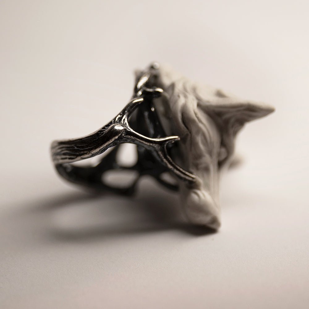 Fox ring - white variant - on its side, on a white background, sterling silver twigs align with overall eerie and "frosty" mood of the image