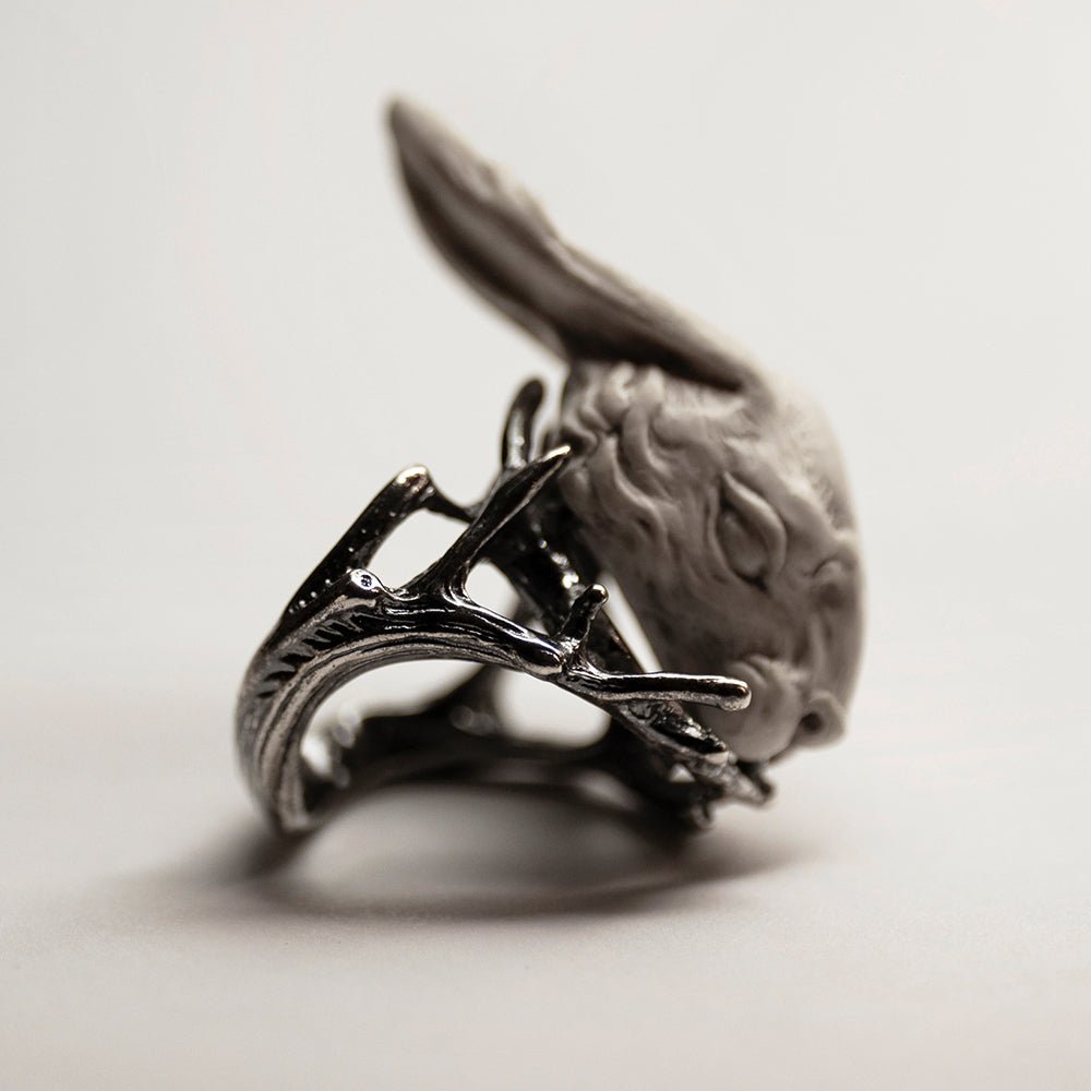Hare ring - white variant - on the white surface, on its side, twigs and hare's sculpted details are visible