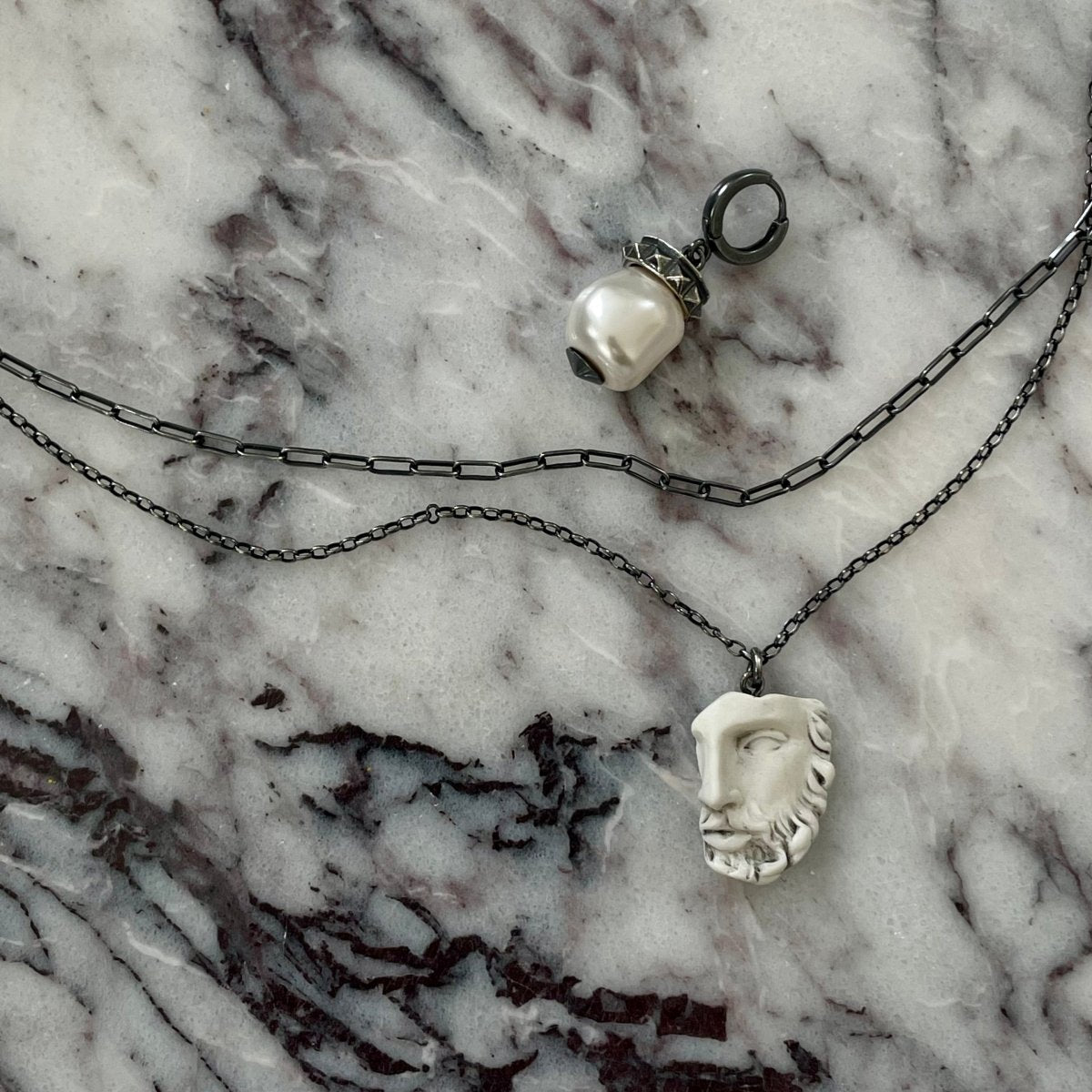 Heracles pendant - silver variant - on marble surface, shows charm and double chain