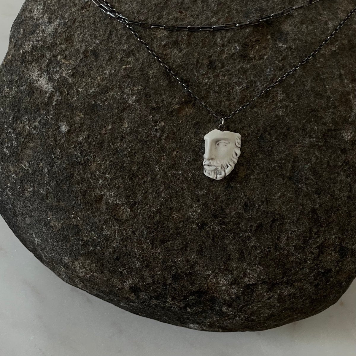 Heracles pendant - silver variant - placed on raw stone surface