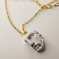 Heracles pendant, crafted from bonded marble, depicts the face of a classical statue with impressive detail, on gold-plated sterling silver chain
