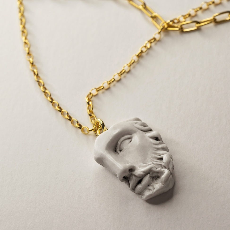 Heracles pendant, crafted from bonded marble, depicts the face of a classical statue with impressive detail, on gold-plated sterling silver chain