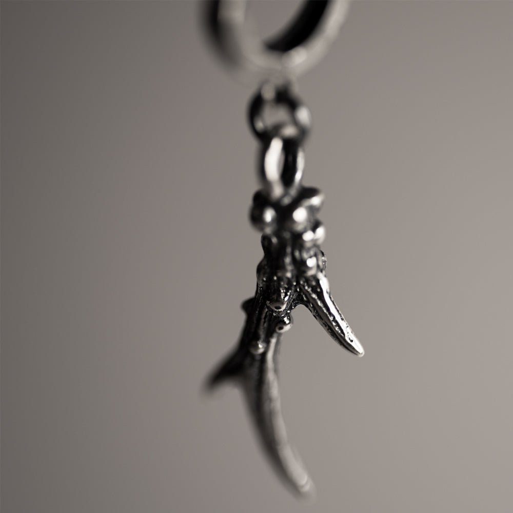 Close-up of Horn earring - focus on sculpted texture of sterling silver gothic hoop earring 