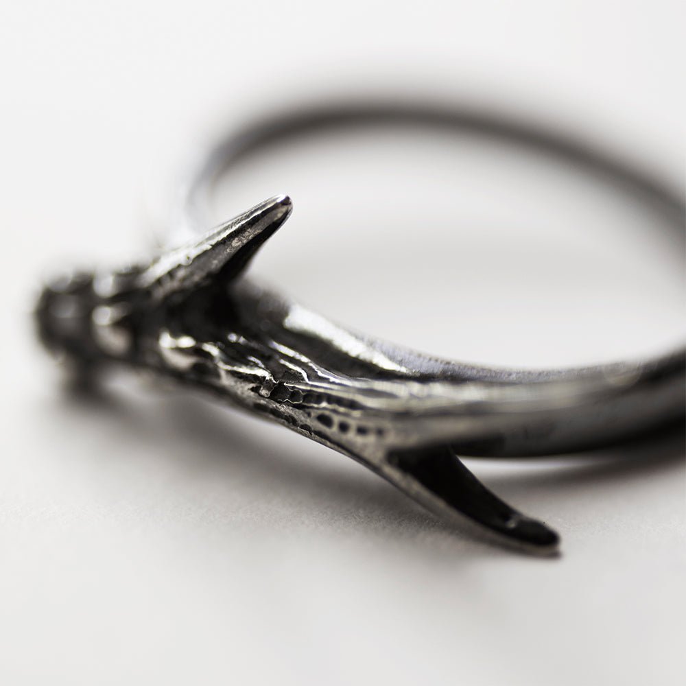 Horn ring on a white surface, close up, focus on horn's texture