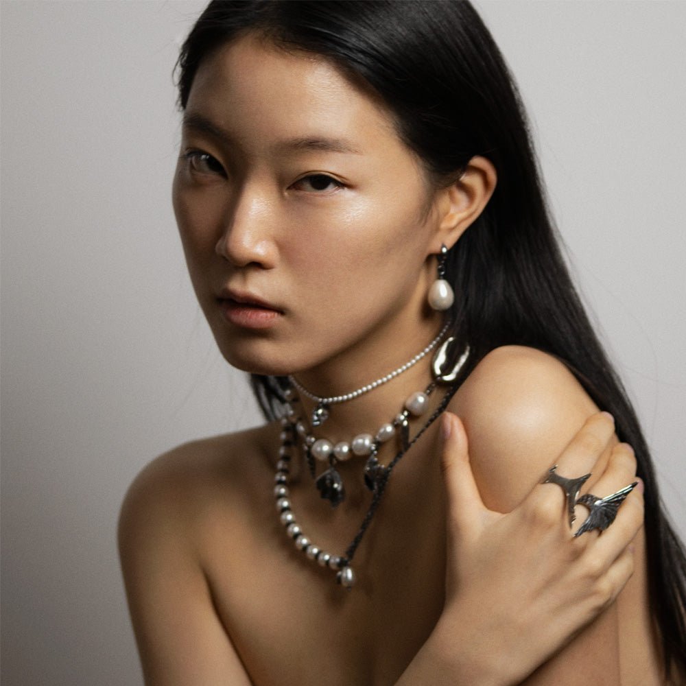Large pearl earring styled on a Korean female model along with other jewelry by Macabre Gadgets
