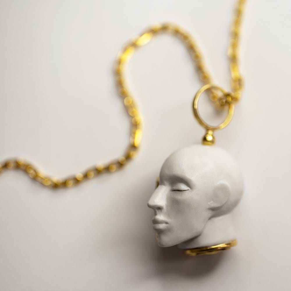 Oracle Skull pendant on a white surface, focus on the marble part of the pendant and its fixture to the anchor chain