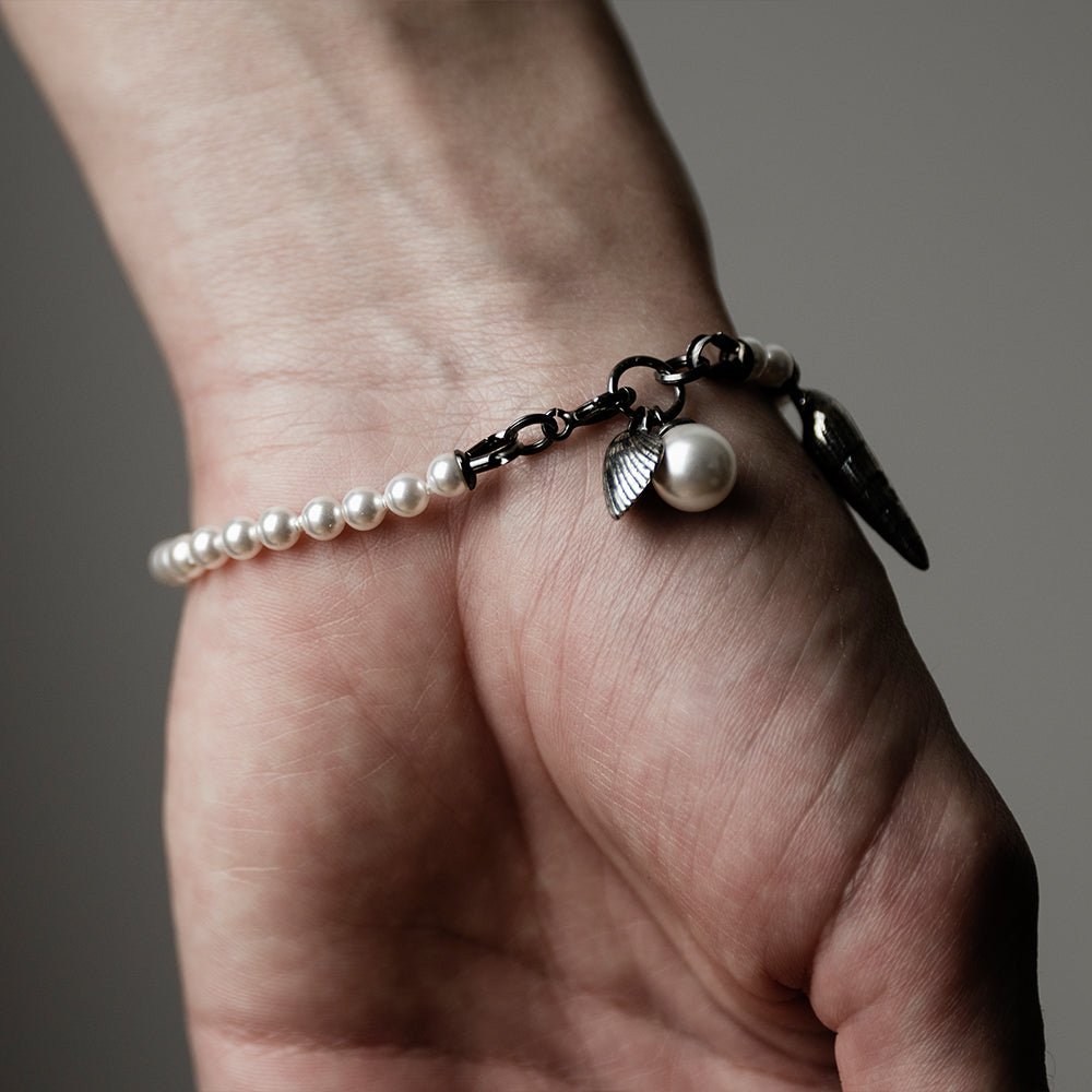 Pearl & Shell Bracelet on a wrist, back side visible, to display a lobster lock and its fixture to the bracelet