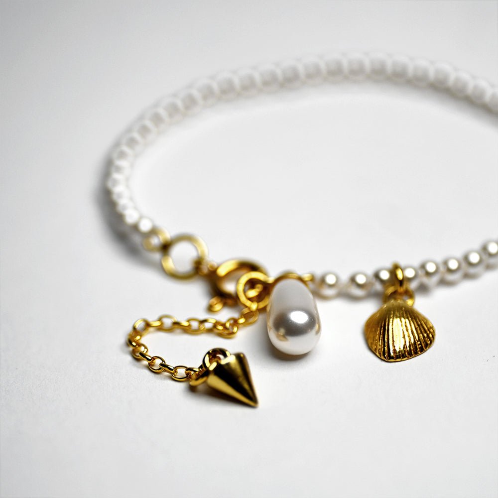 Pearl Bracelet - gold - placed on a white surface, focus on size-adjustable chain