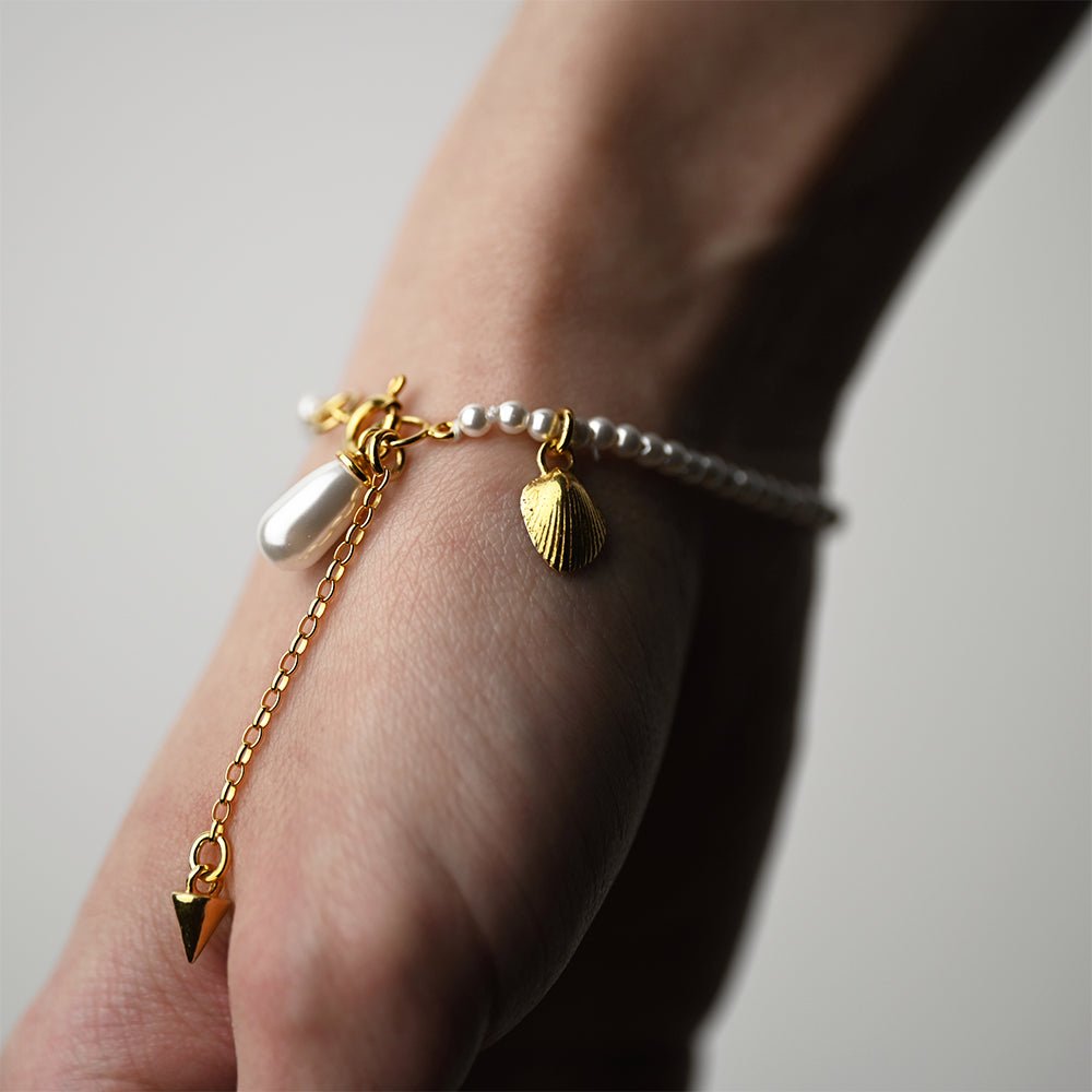Pearl Bracelet - gold, on a wrist - close up of size-adjustable chain and both charms