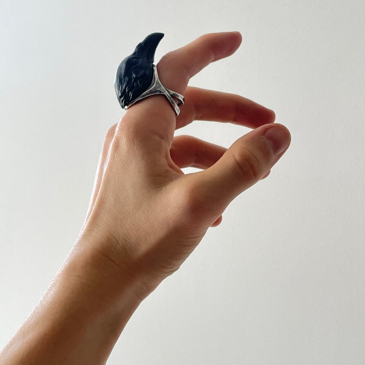 Raven ring - black variant - on a model's hand, index finger, to show general dimensions and fit