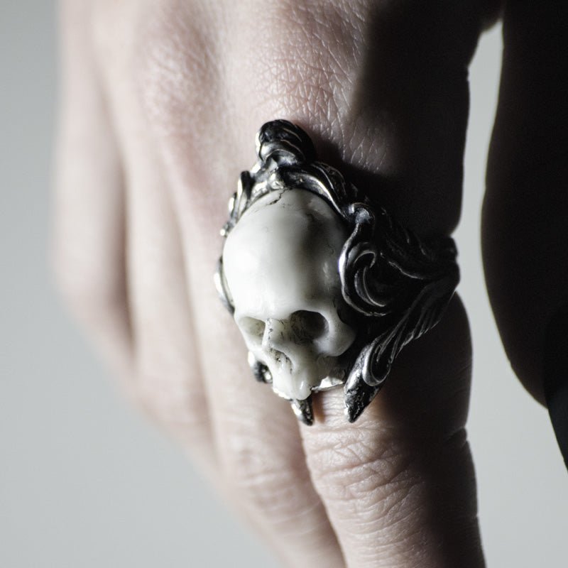 A marble skull set in a solid sterling silver rocaille ring on a hand - heavy skull jewelry by Macabre Gadgets