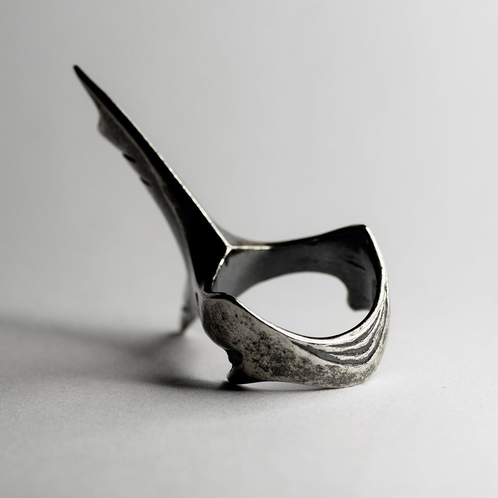 Shark Tail ring on neutral surface - focus on sterling silver texture and ring details