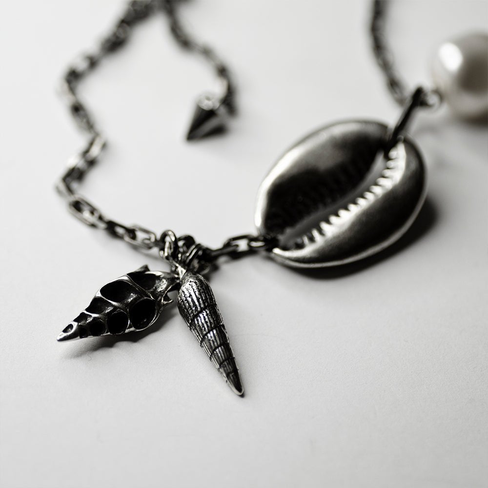 Shell Bracelet - on a white surface, close up of seashells charms