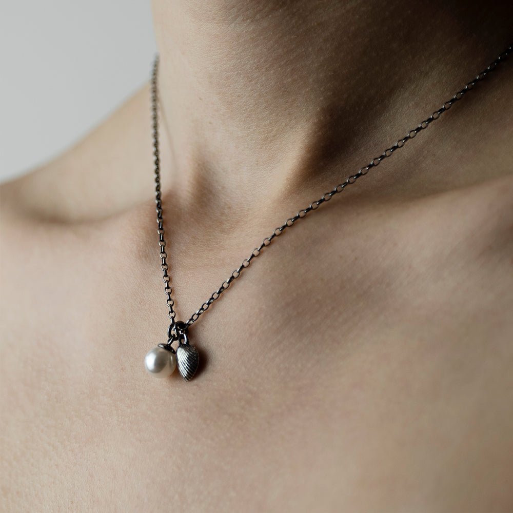 Shell & Pearl pendant on a model's neck - ocean inspired dainty chain necklace with two charms