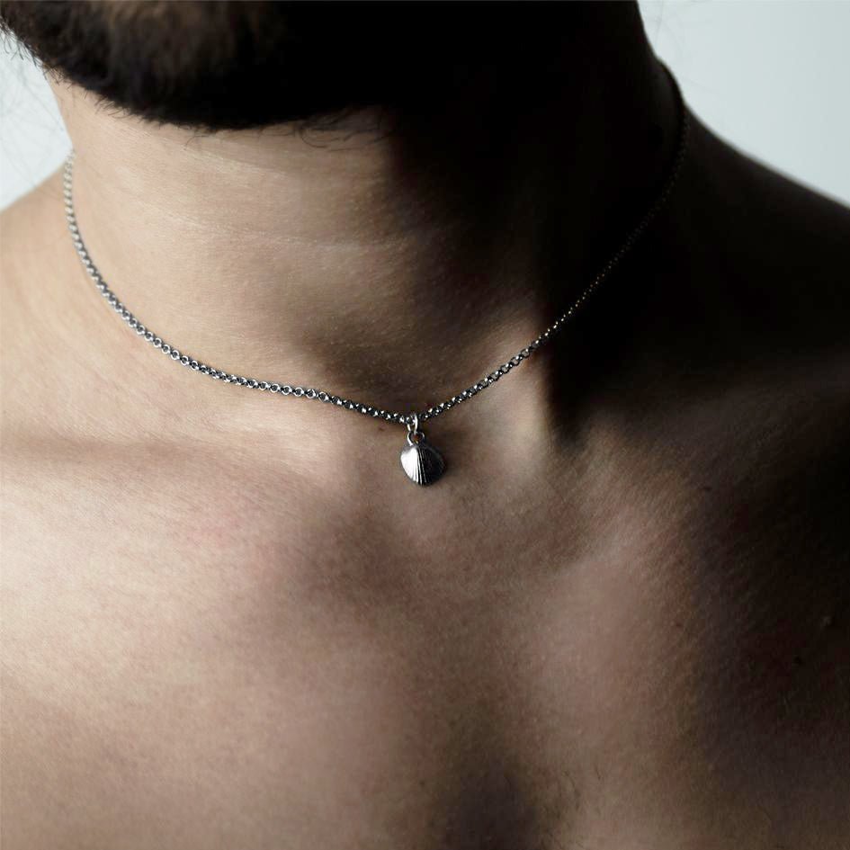 Shell & Pearl pendant - silver variant - on a male model, styled tightly around his neck like a chocker with small silver shell
