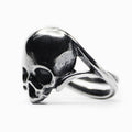 Silver skull ring - semi-profile view, ring placed on a white background, double bend detail is visible
