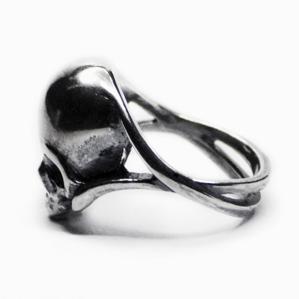 Silver skull ring - semi-back view, focus on the elegantly twisted double band
